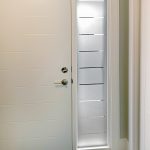 Long glass window next to a door with privacy film in an attractive design